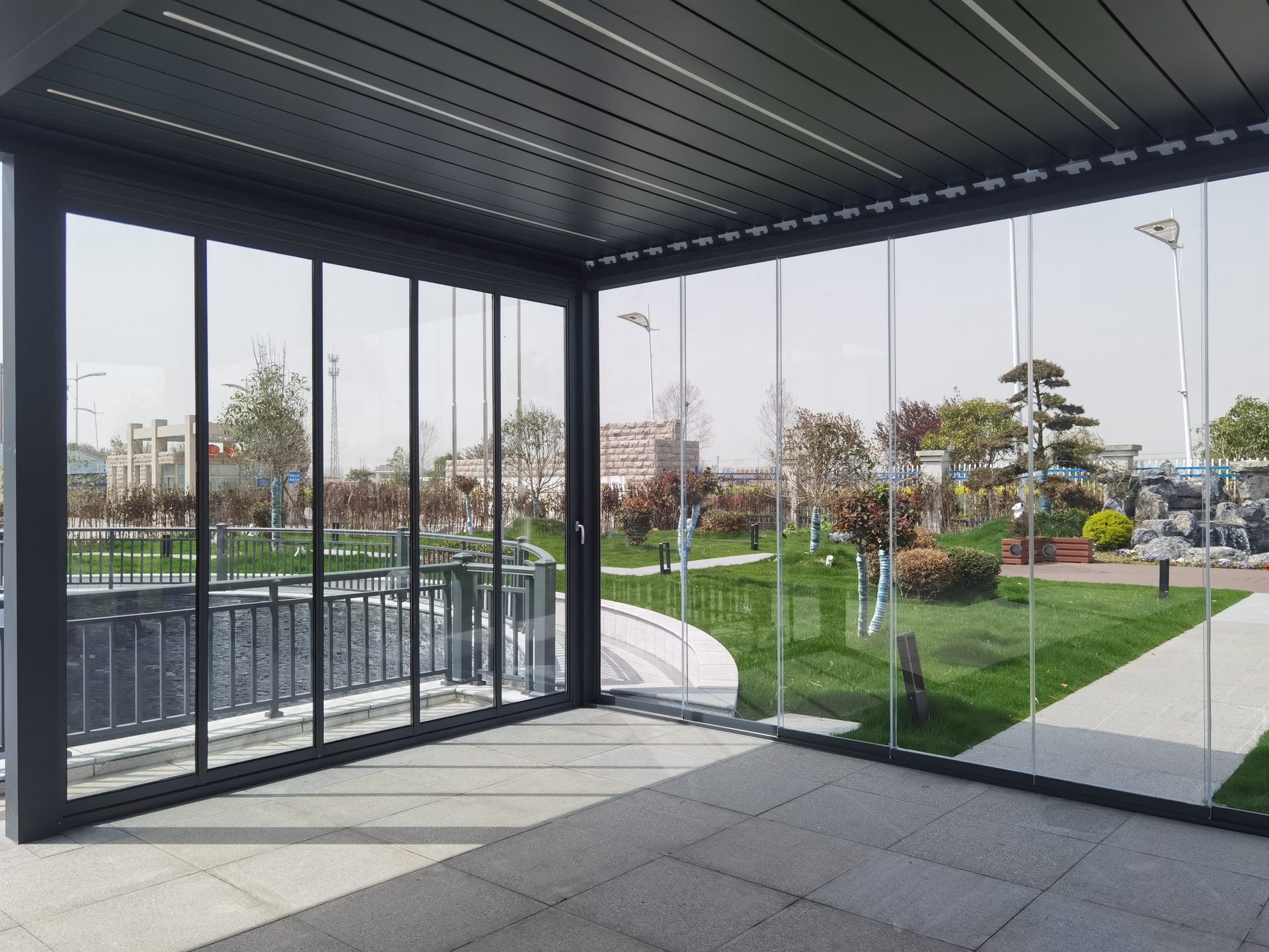 Louvered pergola with glass walls in a modern garden